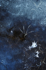 Thin transparent ice on the surface of the reservoir in late autumn