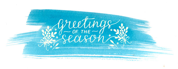 Holiday christmas inscription Greeting of the season, made hand lettering on blue watercolor background