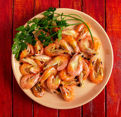 Shrimp and parsley on a red plate. The view from the top.