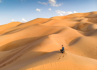 person in Liwa desert, part of Empty Quarter, the largest continuous sand desert in the world