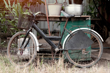Fototapeta na wymiar Old Bicycle parked against the wooden table with empty home appliances.