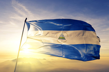 Nicaragua Nicaraguan flag textile cloth fabric waving on the top sunrise mist fog