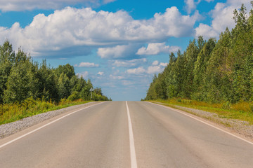 Road through green deep forest in Russia
