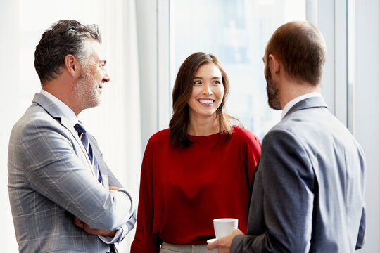 Businessmen Looking At Female Colleague In Meeting
