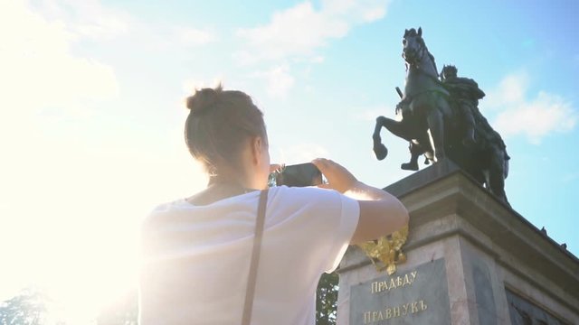 Woman photographs a monument to Peter the first in Saint-Petersburg.
