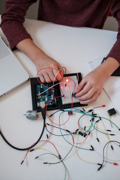 Boy working on an electronic DIY kit at home