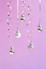 Fototapeta na wymiar Trendy pastel christmas background. Silver ball Ornaments hanging on ultraviolet background. minimal christmas concept. Gradient