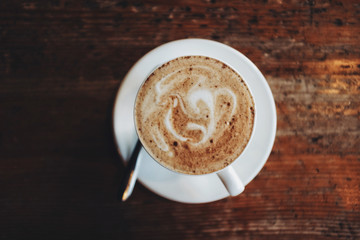 Cup of cappuccino on wooden background