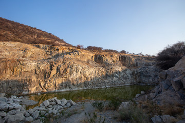 Fels spiegelt sich im Wasserloch