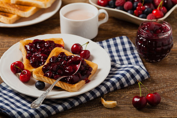 Breakfast. Toasts with cherry or peach jam and fresh fruit.