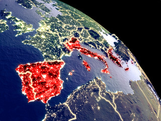 Southern Europe at night from orbit. Plastic planet surface with visible city lights.