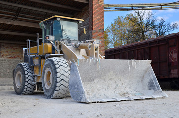 Fototapeta na wymiar Wheel loader on a construction site. Diesel bulldozer with bucket
