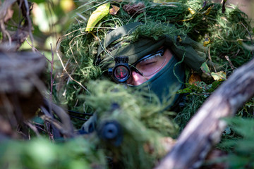 special forces, soldier assault rifle with silencer, optical sight. behind cover waiting in ambush