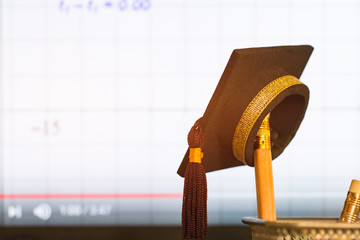 Education Graduate study concept: Graduation hat on pencils with formula arithmetic equation graph...