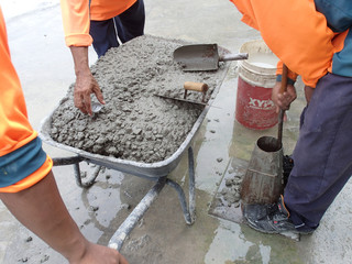 Construction workers doing slump test using specific equipment at the construction site. Witness by...