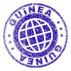 GUINEA stamp imprint with distress texture. Blue vector rubber seal imprint of GUINEA title with unclean texture. Seal has words placed by circle and planet symbol.