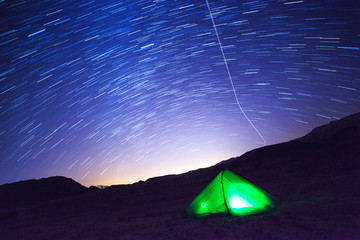 A tent glows under a night sky full of stars. Timna national Park, Israel © Alexandra Lande