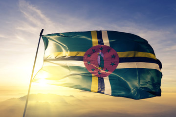 Dominica Dominiquais flag textile cloth fabric waving on the top sunrise mist fog