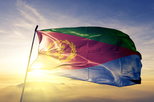 Eritrea Eritrean flag textile cloth fabric waving on the top sunrise mist fog