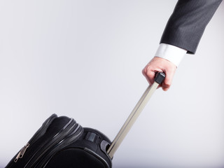 Hand of a businessman with a suitcase handle. The concept of business trips