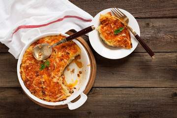 Shepherd's pie, traditional British dish with minced meat and mashed potato on rustic wooden table.