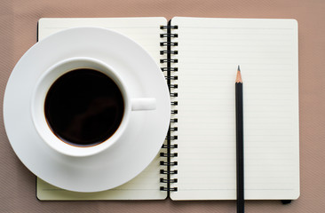 Coffee in white cup with Journal book and pencil
