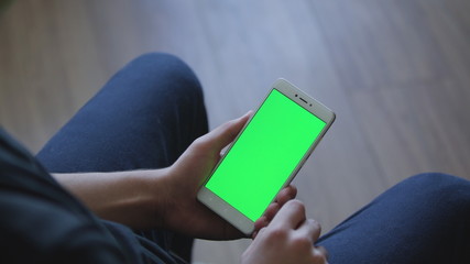 Closeup of male hands holding smart phone with green screen prekeyed for effects. Useful mobile application booking, ordering services, shopping online. Modern communication technology, gadget games