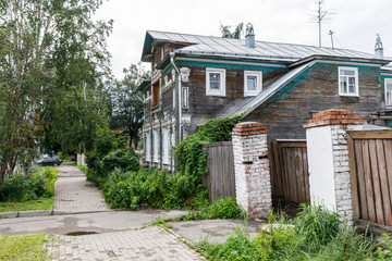 Wooden house with carved polisade in Vologda. Russian traditional architecture lies in wooden houses with manually carved decorations, often painted in white
