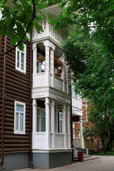 Fototapeta na wymiar Wooden house with carved polisade in Vologda. Russian traditional architecture lies in wooden houses with manually carved decorations, often painted in white