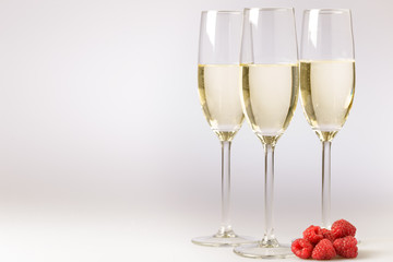 Elegant flutes of champagne with fresh raspberries
