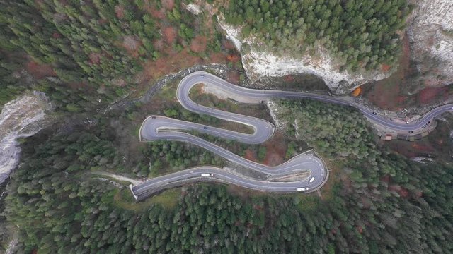 Extreme winding road in the mountains trough a forest aerial video footage shot in Bicaz Gorge Transylvania using a drone