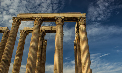Fototapeta premium tourism to ancient heritage of antique columns ruins of old temple buildings in area of outdoor open air museum, blue sky background