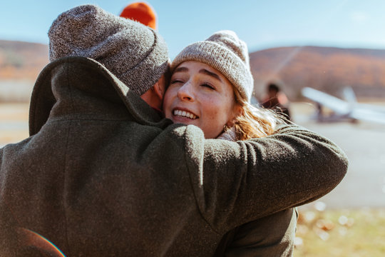 Friends hugging on an airfield after flying glider planes