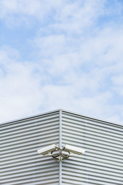 Two security cameras on the corner of a modern building