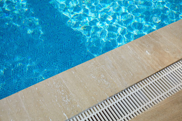 surface of blue swimming pool,background of water in swimming pool. Ripple Water in swimming pool with sun reflection.