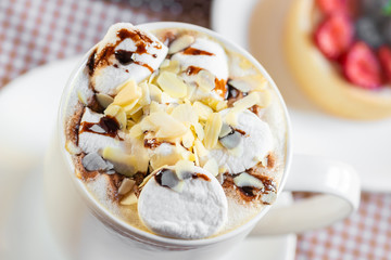 cup of coffee with marshmallow and topping with nuts