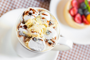 cup of coffee with marshmallow and topping with nuts