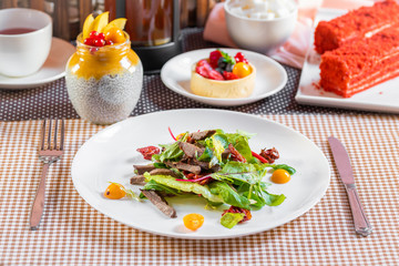 Salad with meat, arugula, algae, tomatoes and greens