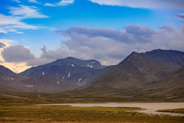 Beautiful mountain landscape. Relax in fresh air. Blue sky with clouds. Mountain peaks with snow andrava