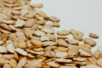Dried split broad beans loose on white background. 