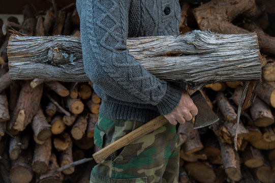 Man in a wool winter sweater holding an ax