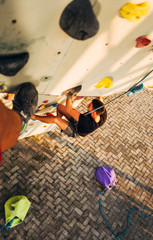 Fototapeta premium Sportive man climbs up on artificial rock wall