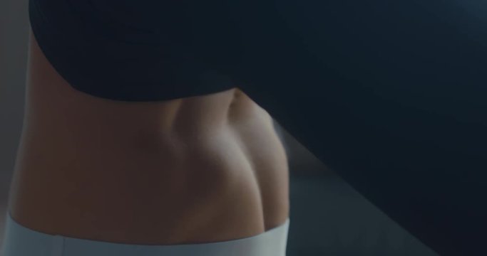 EXTREME CU view of slim female belly while practicing yoga. 4K UHD