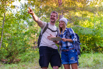 Fototapeta premium Young couple walking in the forest. Hiking concept in the mountain in summer