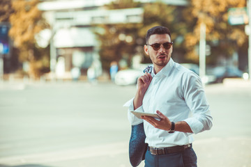 Elegance businessman standing outdoors with the notebook