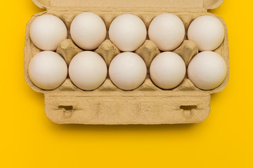 eggs in a cardboard box on a yellow background