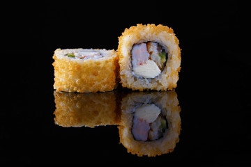 appetizing baked sushi roll with fish on a black background with reflection