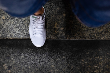 Ragazzo con scarpe da ginnastica mentre scende le scale