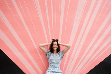 Woman being silly in front of pink wall