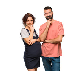 Couple with pregnant woman smiling and looking to the front with confident face on isolated white background